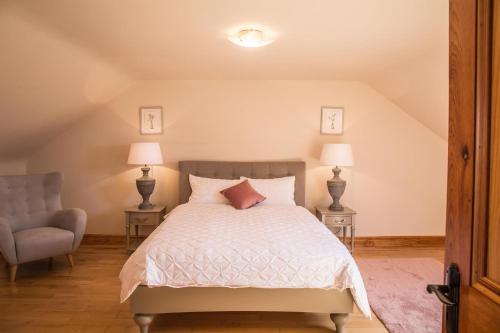 a bedroom with a bed and a chair and lamps at Once Upon a Tide in Clifden