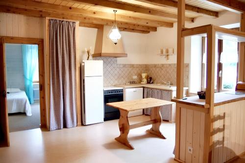 a kitchen with a refrigerator and a table in it at Appartement de 3 chambres avec jardin amenage et wifi a Plancher les Mines a 7 km des pistes in Plancher-les-Mines