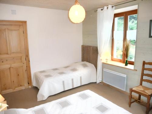 a bedroom with two beds and a window and a chair at Appartement de 3 chambres avec jardin amenage et wifi a Plancher les Mines a 7 km des pistes in Plancher-les-Mines