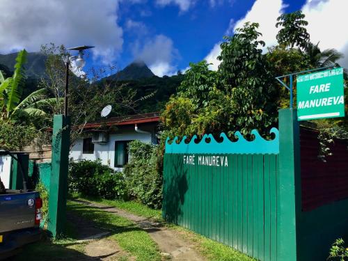 a green fence with a sign on it at Faré Paloma Moorea in Moorea