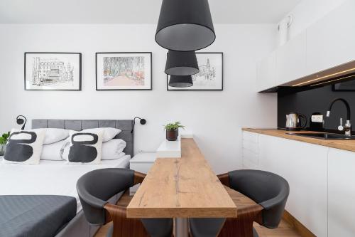 a kitchen with a wooden table and black chairs at Studio with a balcony and AC - Rajska 3 street in Kraków