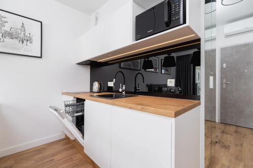 a kitchen with a sink and a microwave at Studio with a balcony and AC - Rajska 3 street in Kraków