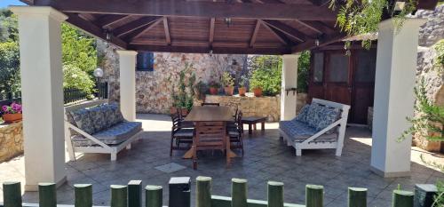 a patio with a table and chairs under a pergola at Trullo Grande Noce in Ostuni