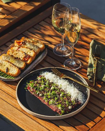 a table with a plate of food and glasses of wine at Naatooh Guest Houses in Florianópolis