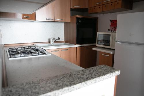 Una cocina con estufa y refrigerador blanco. en IseoLakeRental - Casa Angelica, en Riva di Solto