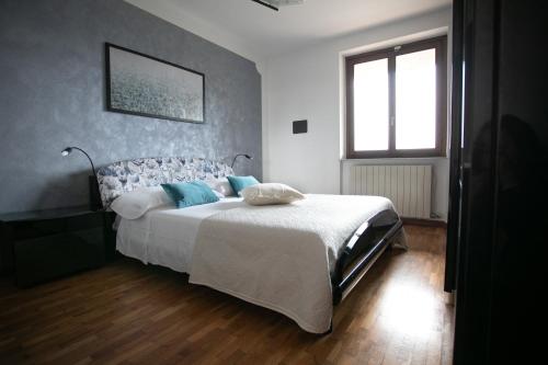Un dormitorio con una cama grande con almohadas azules. en IseoLakeRental - Casa Angelica, en Riva di Solto