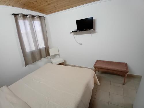 a bedroom with a bed and a tv on the wall at Case vacanze Leo & Cristina in Peschici