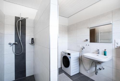 uma casa de banho com uma máquina de lavar roupa e um lavatório em Wäller Abendsonne em Westerburg