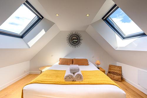 - une chambre mansardée avec un lit et des lucarnes dans l'établissement L'écrin du crouesty - Belle Maison pour 6, à Arzon