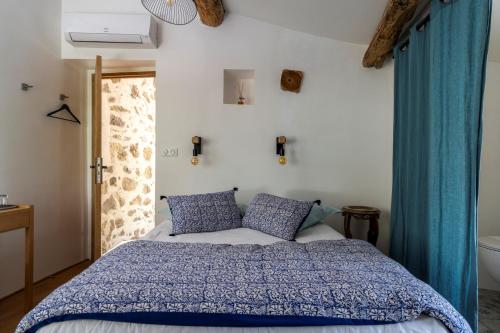 een slaapkamer met een bed, blauwe gordijnen en een bad bij Mas Osmeea in Roquefort-les-Pins