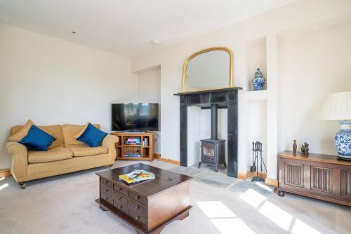 a living room with a couch and a fireplace at Pass the Keys Fourshires Lodge Wonderful panoramic views in Moreton in Marsh