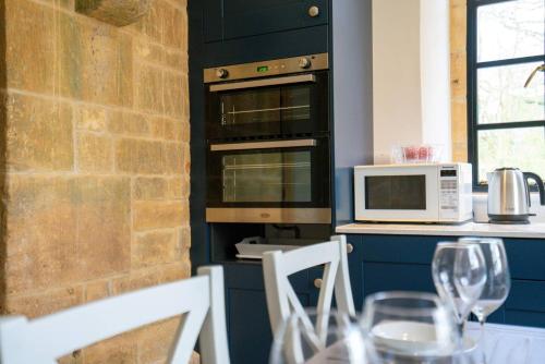 a kitchen with a table with glasses of wine at Pass the Keys Fourshires Lodge Wonderful panoramic views in Moreton in Marsh