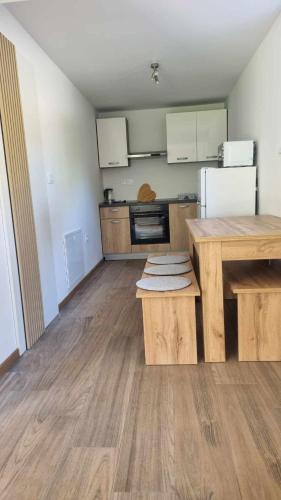 an empty kitchen with a wooden table and refrigerator at apartment Sun Di Bohinj in Bohinj