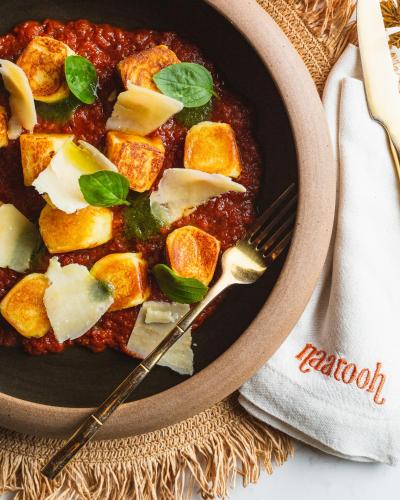 a bowl of stew with tofu and cheese and a fork at Naatooh Guest Houses in Florianópolis