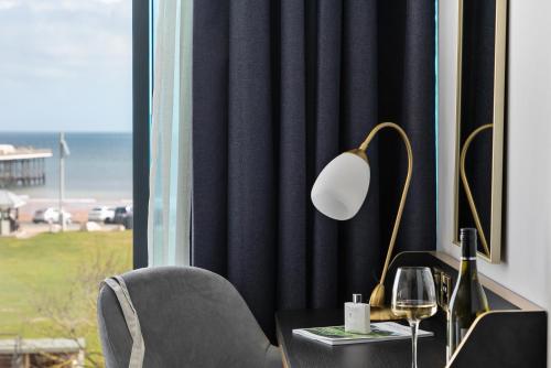 a desk with a lamp and a chair next to a window at Mercure Paignton Hotel in Paignton