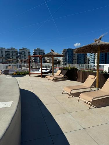 een rij ligstoelen en parasols op een dak bij Marina Club Luxury private studio with Pool and incredible views in Gibraltar