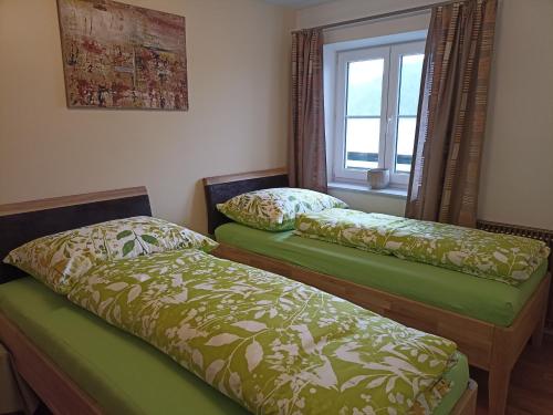 2 camas en una habitación con ventana en Ferienwohnung Mayrhofer, en Innerschwand