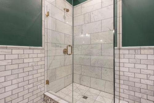 a shower with a glass door in a bathroom at Penthouse Grand Executive Suite in Louisville