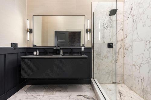 Penthouse Grand Executive Suite في لويزفيل: حمام مع حوض ومرآة