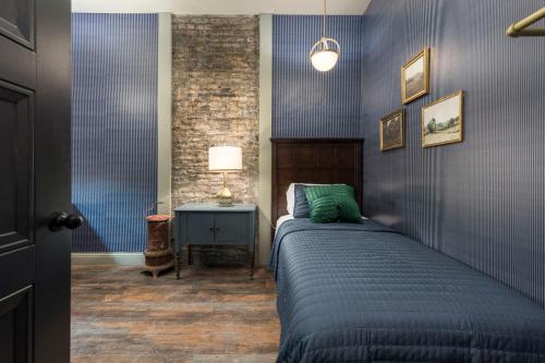 Penthouse Grand Executive Suite في لويزفيل: غرفة نوم بسرير وجدار ازرق
