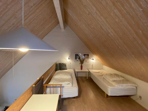 a attic room with two beds and a table at Holiday home in resort in Skagen with public pool in Skagen