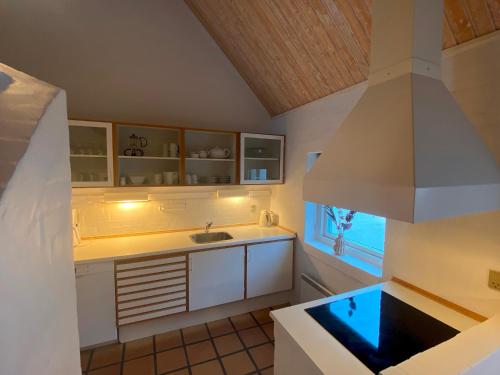 a kitchen with white cabinets and a sink at Holiday home in resort in Skagen with public pool in Skagen