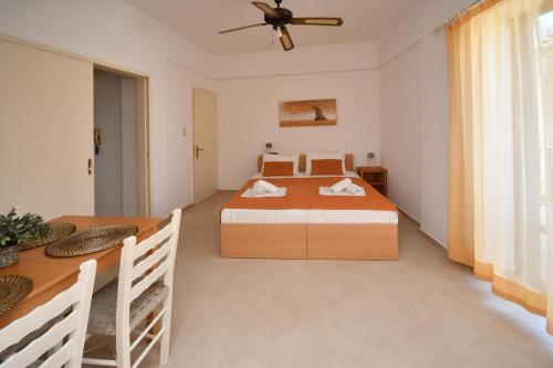 a bedroom with a bed and a dining table at Nikos House in Myrtos
