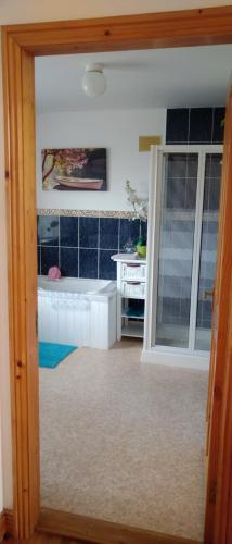a bathroom with a tub and a sink in a room at Moor House in Kilmuckridge