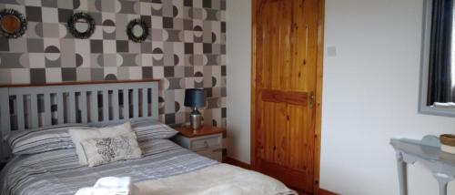 a bedroom with a bed and a checkerboard wall at Moor House in Kilmuckridge