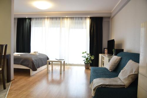 Kraków Apartments - Friedleina Studio Apartments في كراكوف: غرفة نوم مع أريكة وسرير ونافذة