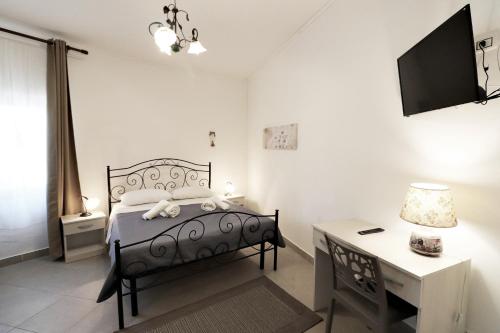 sypialnia z łóżkiem, biurkiem i telewizorem w obiekcie La Pietra Village Rooms w mieście Ruffano