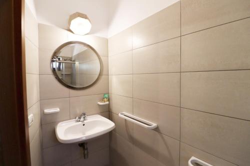 W łazience znajduje się umywalka i lustro. w obiekcie La Pietra Village Rooms w mieście Ruffano