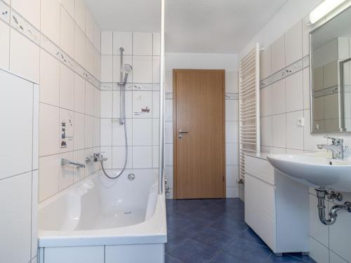 ein Bad mit einer Badewanne, einem Waschbecken und einer Dusche in der Unterkunft Schulstraße FeWo S4 (DG links) in Prerow