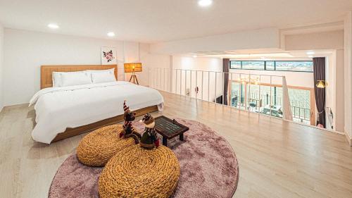 a large bedroom with a bed and a rug at Majoong Pool Villa Pension 