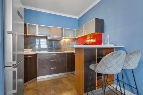 a kitchen with a counter and two bar stools at Tomato Apartment - With free parking in Bratislava