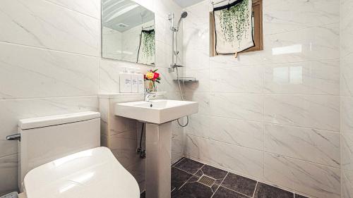 a white bathroom with a toilet and a sink at Majoong Pool Villa Pension 