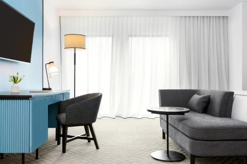 a living room with a desk and a chair and a table at Kimpton Hotel Fontenot, an IHG Hotel in New Orleans