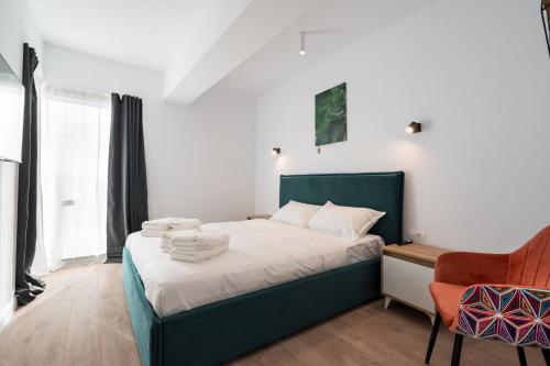 um quarto com uma cama com toalhas em Pastel Green I 1 BR apt with terrace em Voluntari