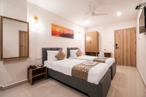 a hotel room with two beds and a mirror at Hotel Seasons Inn in Nellore