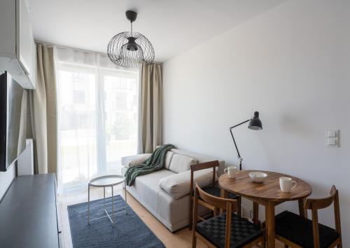 a living room with a couch and a table at Apartament Sztutowo by Ski and Sea in Sztutowo