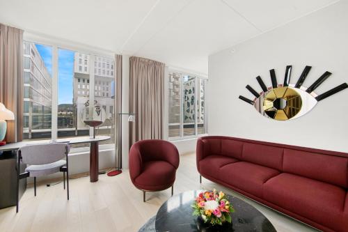 a living room with a red couch and a table at Clarion Hotel Oslo in Oslo