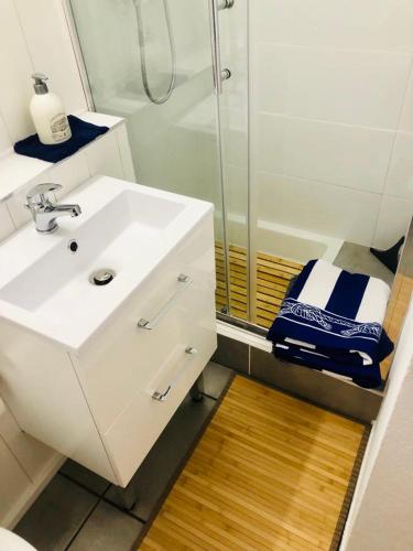 une salle de bain avec un lavabo blanc et une douche dans l'établissement Stylish studio close to beach in residence with pool, à Narbonne