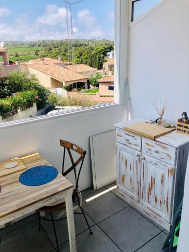une cuisine avec une table et une fenêtre avec vue dans l'établissement Stylish studio close to beach in residence with pool, à Narbonne