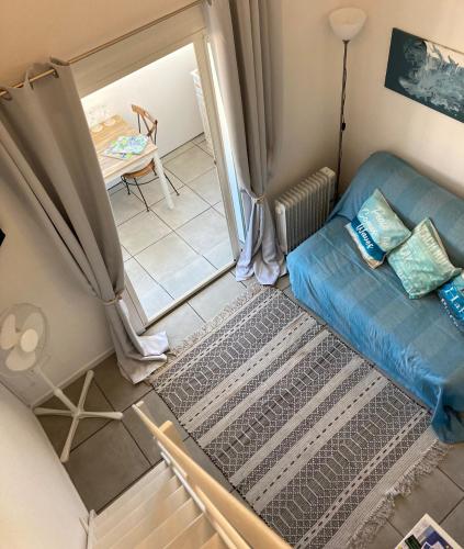 un salon avec un canapé bleu et une table dans l'établissement Stylish studio close to beach in residence with pool, à Narbonne