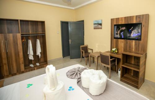 a living room with a television and a dining room at Mankoview Beach Resort in Winneba