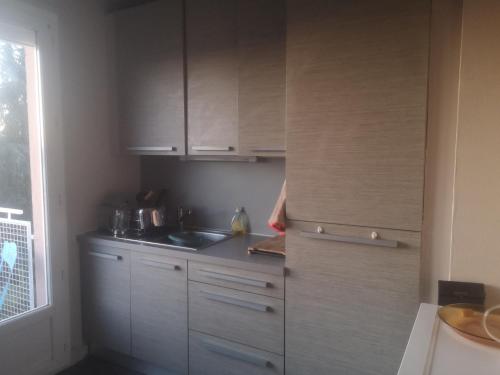 une cuisine avec des armoires blanches et un évier dans l'établissement Le pastel, à Albi