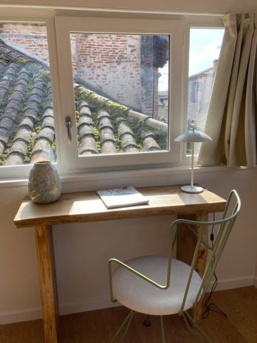 a desk with a chair in front of a window at LA SIESTE in Cahors