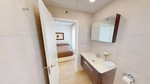 La salle de bains est pourvue d'un lavabo, d'un miroir et d'un lit. dans l'établissement Villa Solana by Oliva Nova, à Oliva
