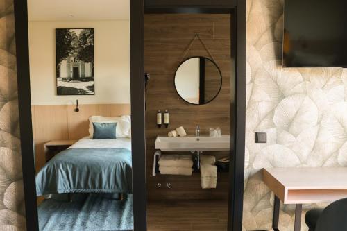 uma casa de banho com uma cama, um lavatório e um espelho. em Quinta da Seixeda em Alijó