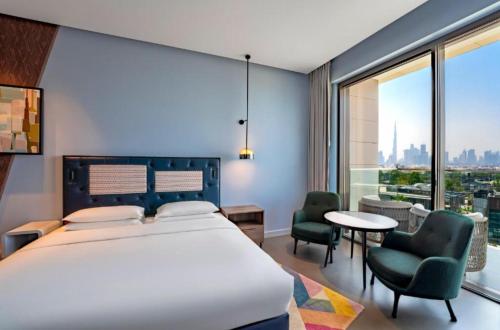 1 dormitorio con 1 cama grande, mesa y sillas en Hyatt Centric Jumeirah - King Room Skyline - UAE, en Dubái